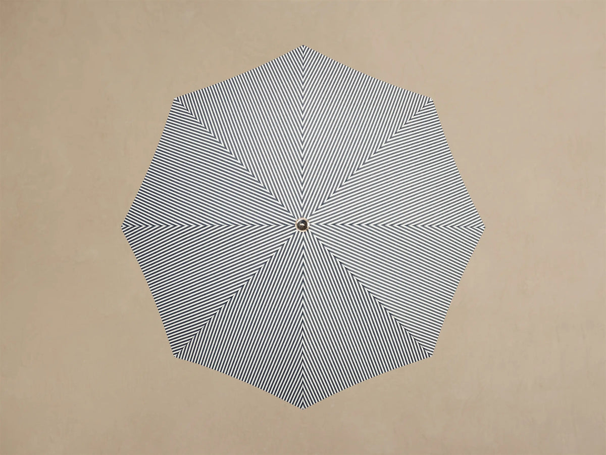 Close-up of the White Ruffled Parasol Base, showing its pleated design, cylindrical white pole, and wooden insert.