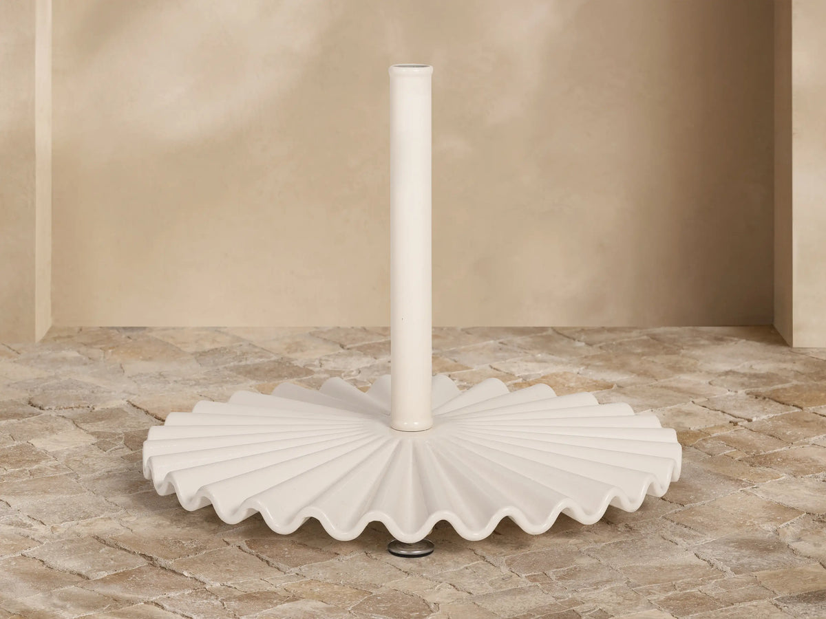 Front view of the white ruffled umbrella base with a central pole.