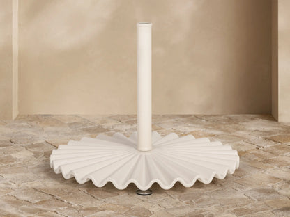 Front view of the white ruffled umbrella base with a central pole.