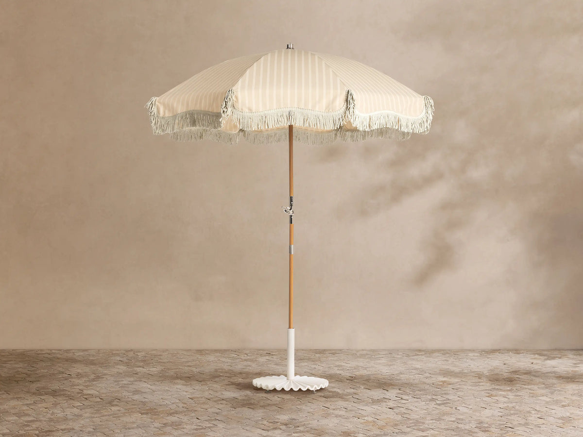 Front view of the white ruffled umbrella base with a central pole.
