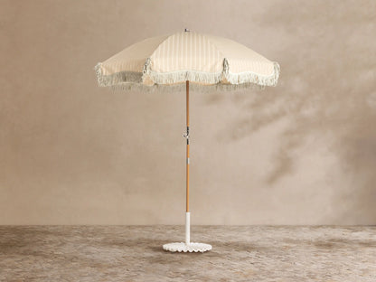Front view of the white ruffled umbrella base with a central pole.