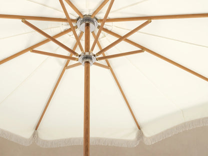 Front view of a cream patio umbrella with decorative fringe, a wooden pole, and a white base.