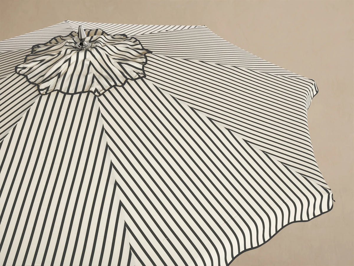 Underside view of an open umbrella with black and cream striped fabric. It features a natural wood frame and silver metal hub.