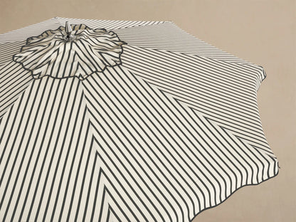 Underside view of an open umbrella with black and cream striped fabric. It features a natural wood frame and silver metal hub.