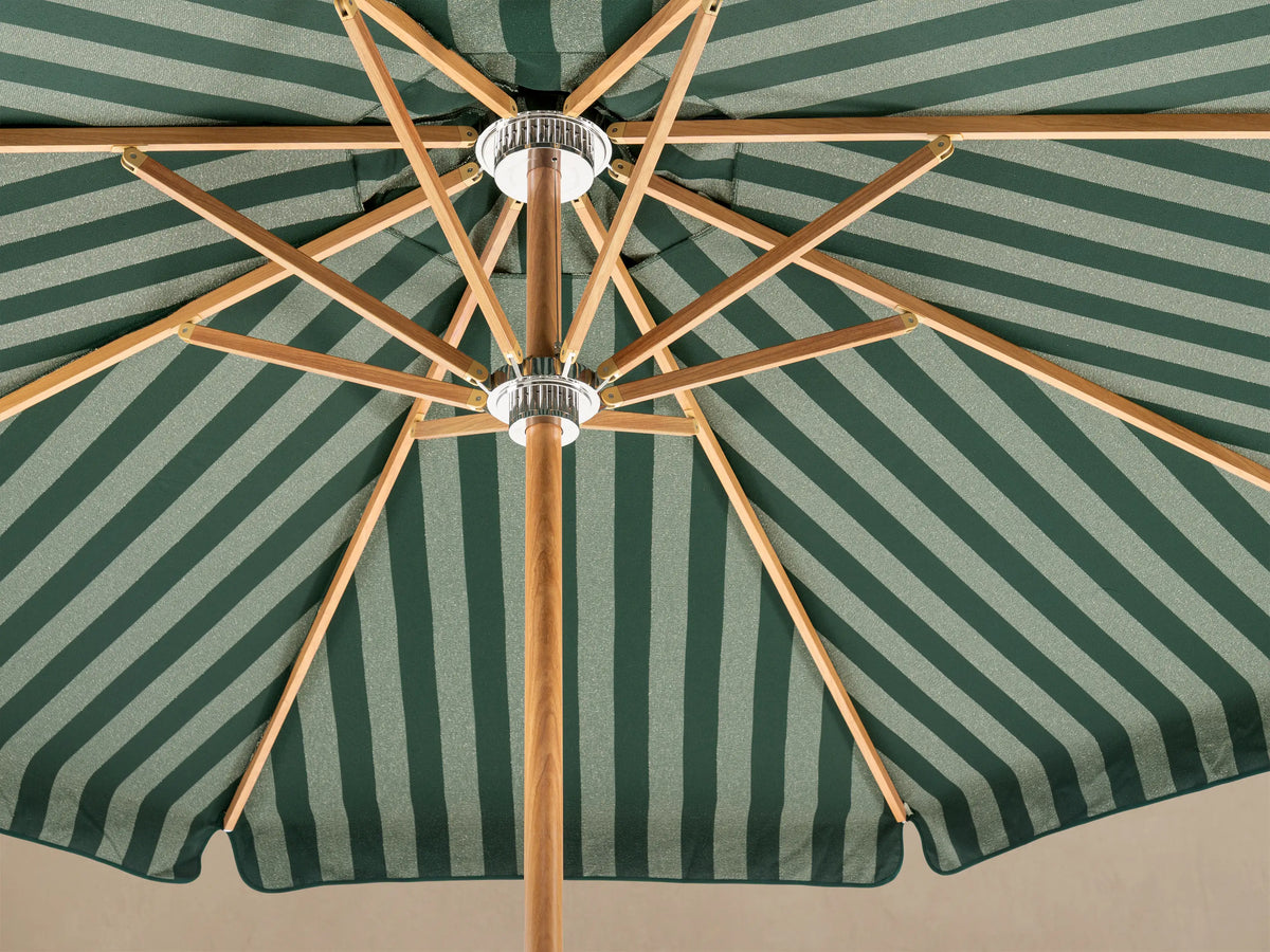 Front view of a patio umbrella with a green and white striped scalloped canopy, wooden pole, and white decorative base.