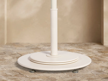 Top view of a green and off-white chevron stripe patio umbrella with a silver finial.