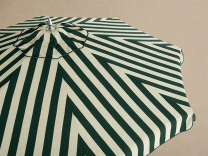 Interior view of an open umbrella with dark green and light beige striped fabric, showing its wooden frame and central pole.