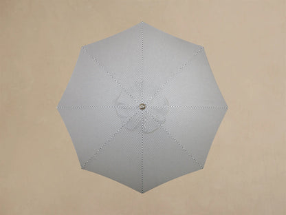 Close-up of the cream-colored circular base of a stand or lamp, featuring a central pole and small silver leveling feet.