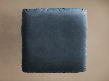 Close-up of the deep teal velvet cushion and brushed silver steel base of the Deacon Ottoman.
