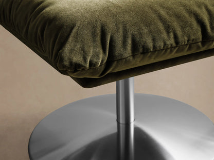 Front view of an olive green Deacon Ottoman with a square cushion and a brushed metal pedestal base.