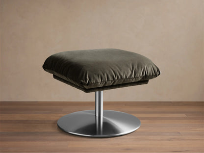 Front view of the dark green cushioned Deacon Ottoman with a circular silver metallic base.
