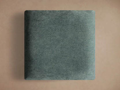 Close-up of the dark teal textured fabric cushion and brushed silver circular base of the Deacon Ottoman.