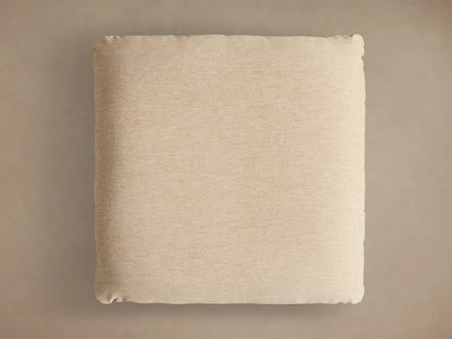 Close-up of the beige upholstered cushion on a gold metallic base of the Deacon Ottoman.