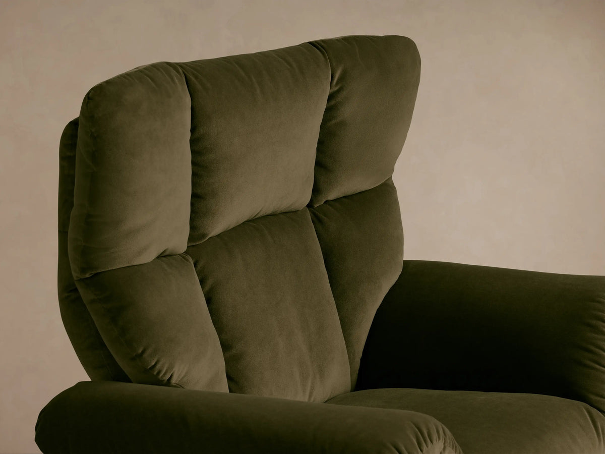 Close-up of the olive green Deacon Swivel Recliner, showing the padded armrest, plush fabric, and side reclining lever.
