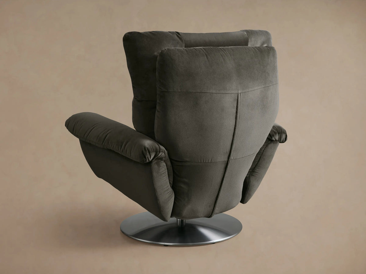 Close-up of the dark gray Deacon Swivel Recliner, showing the plush, channeled backrest and part of the armrest.