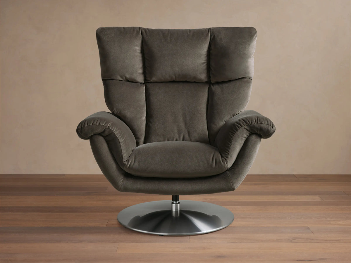 Angled rear view of the Dark grey Deacon Swivel Recliner, showing its padded back, armrests, and silver swivel base.