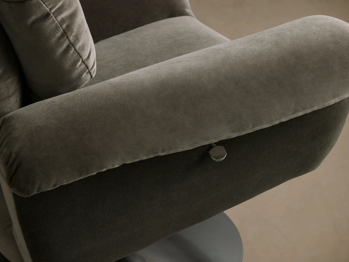 Close-up of the plush, dark grey-green upholstery on the back and armrest of the Deacon Swivel Recliner, showing its channeled cushioning.