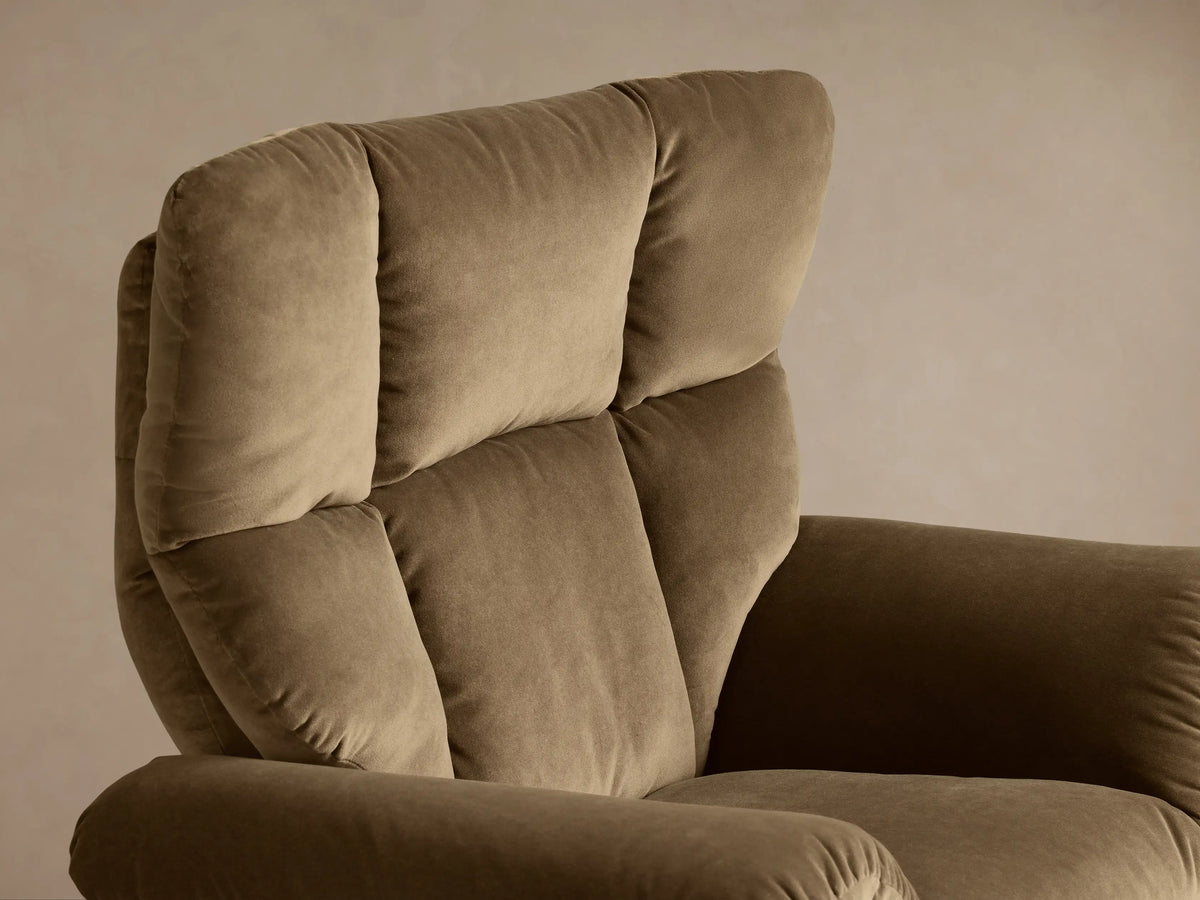 Close-up view of the brown Deacon Swivel Recliner's plush armrest and side, with a silver reclining lever.