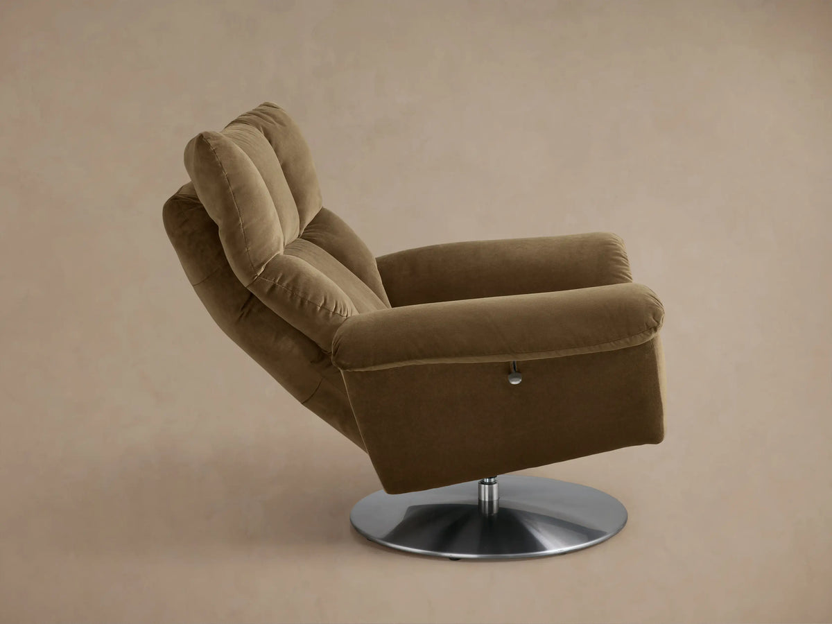 Rear view of the Tan Deacon Swivel Recliner, showing its plush backrest, rolled armrests, and round silver swivel base.