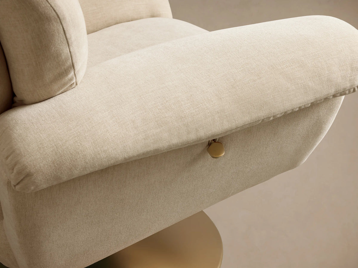 Close-up of the light cream Deacon Swivel Recliner, showing its plush, segmented backrest and armrest from a side angle.