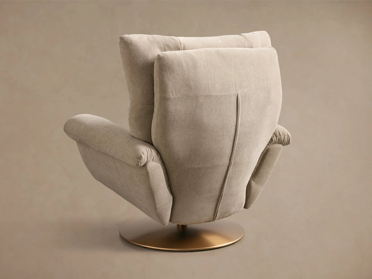 Close-up of the beige fabric armrest of the Deacon Swivel Recliner, with a brass recliner lever.