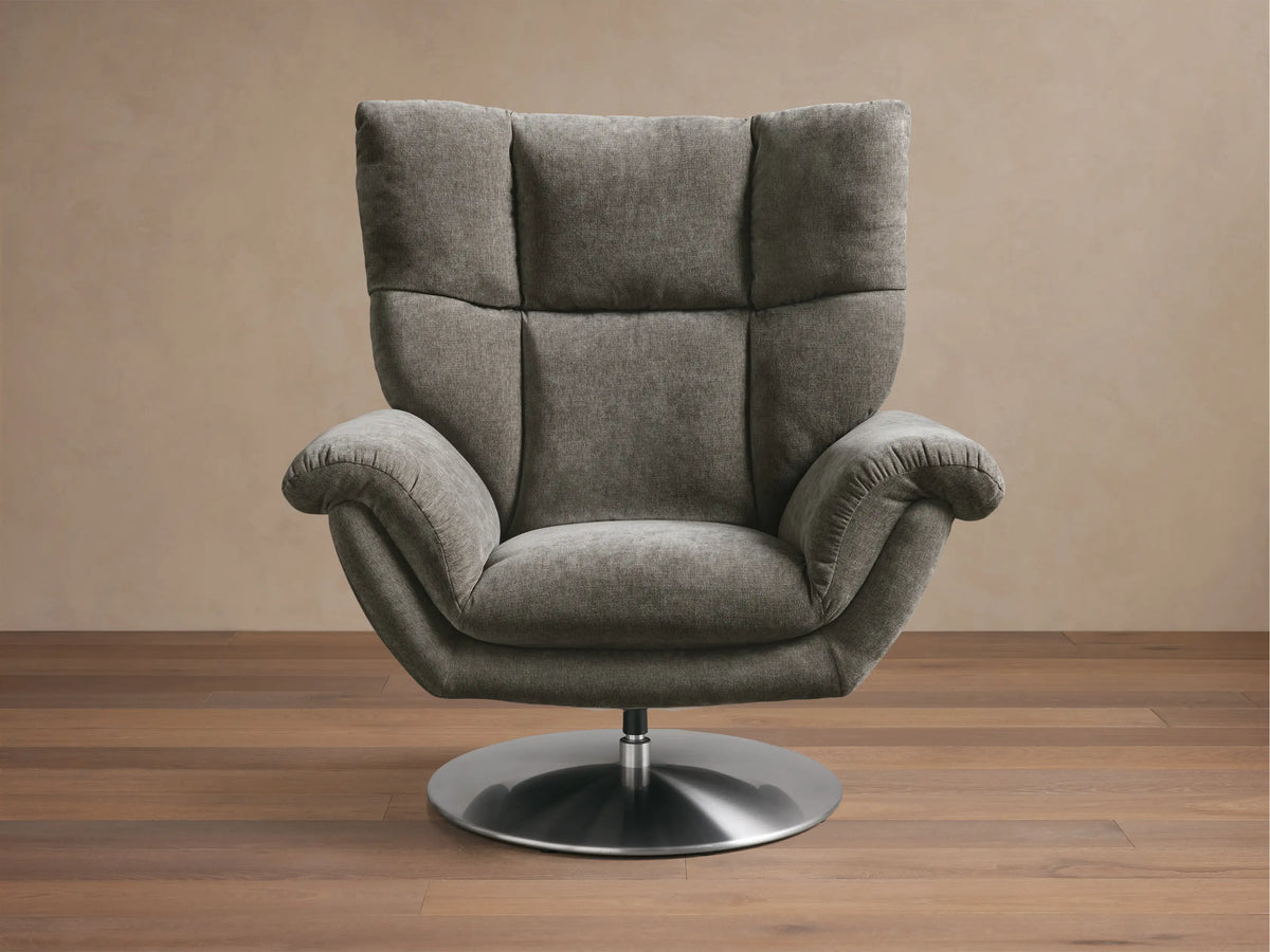 Front view of the light gray Deacon Swivel Recliner with a tufted back, rolled armrests, side lever, and round silver swivel base.