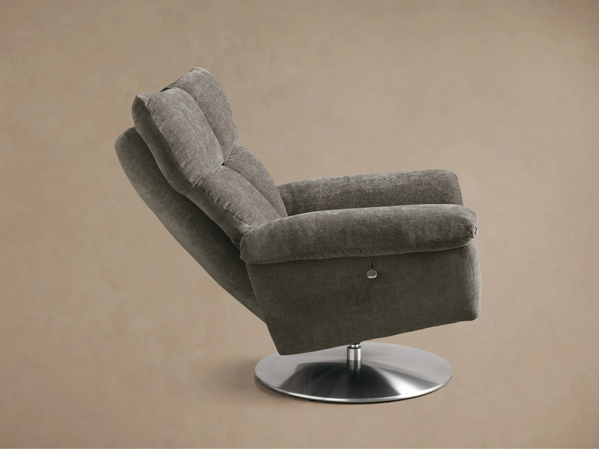 Rear side view of the grey Deacon Swivel Recliner with a brushed steel swivel base.
