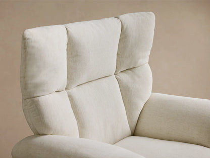 Side-rear view of the cream Deacon Swivel Recliner in textured fabric, with a padded back, vertical seams, and a gold swivel base.