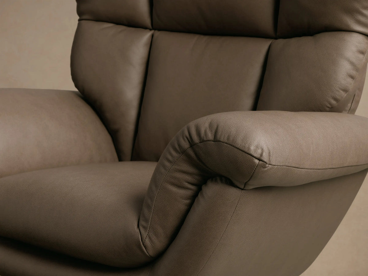 Front view of the Taupe Deacon Leather Swivel Recliner, featuring a plush, sectioned back, rolled armrests, and a black circular base.