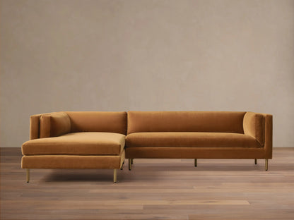Front view of a mustard velvet Malta Two-Piece Chaise Sectional with the chaise on the left and recessed gold legs.