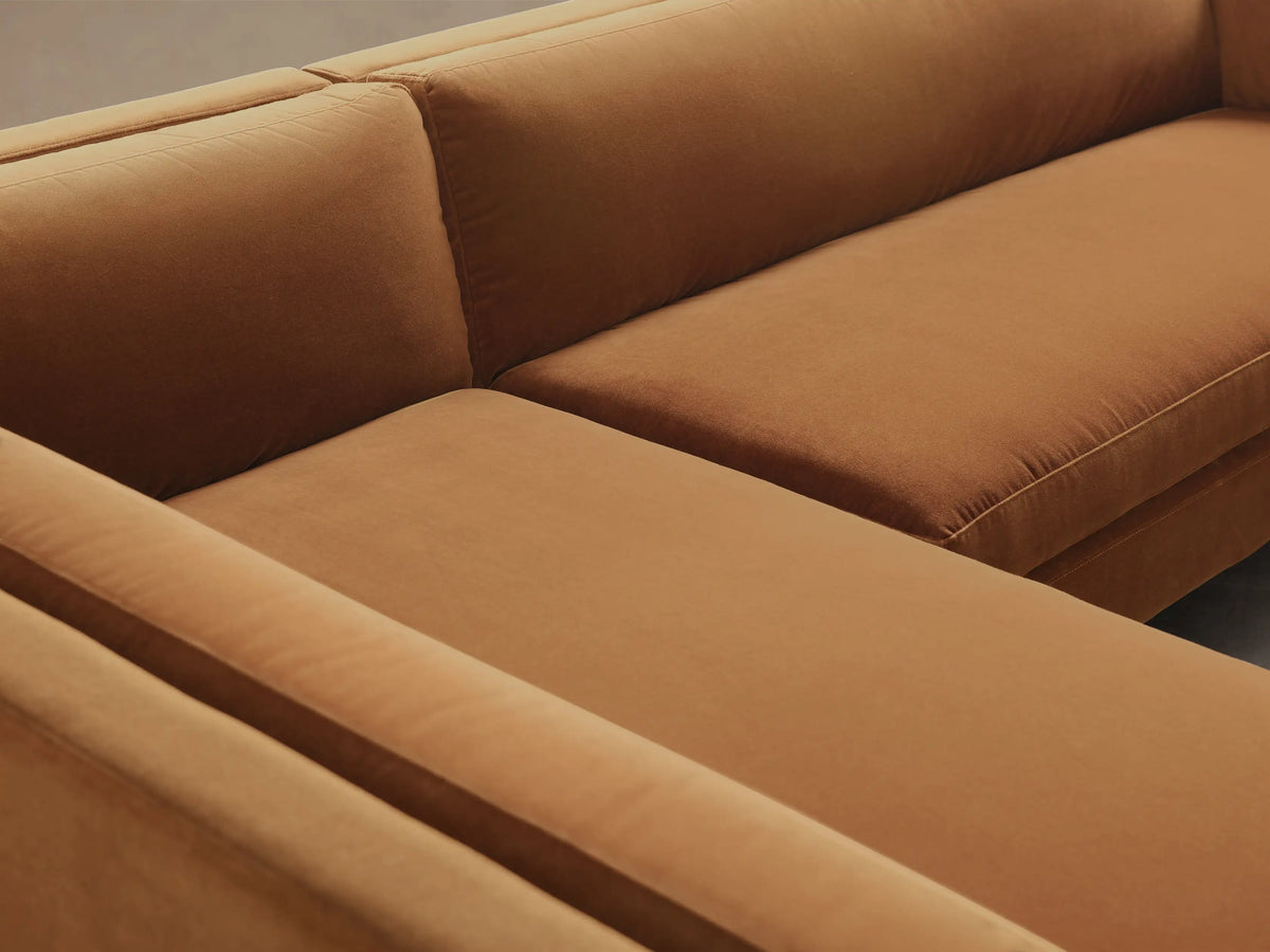 Close-up of the cognac upholstery on the Malta Two-Piece Chaise Sectional, showing plush seat and back cushions with visible seams.