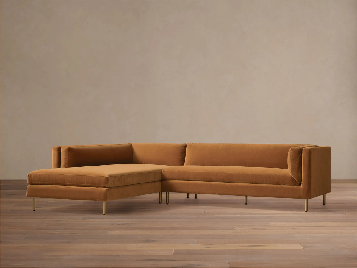 Front view of the rust velvet Malta Two-Piece Chaise Sectional with a left-facing chaise and slender gold legs.