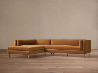 Front view of the rust velvet Malta Two-Piece Chaise Sectional with a left-facing chaise and slender gold legs.