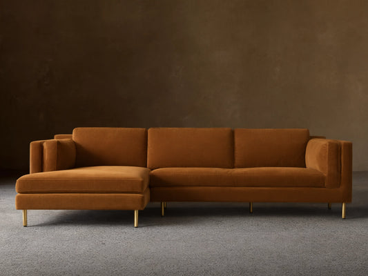 Front view of a mustard velvet Malta Two-Piece Chaise Sectional with the chaise on the left and recessed gold legs.