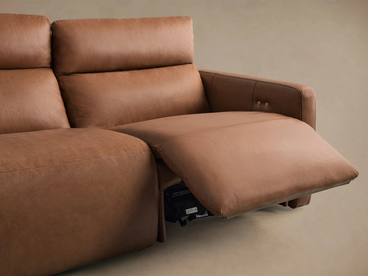 Detail of Rowland Leather Modular Sofa: brown textured leather backrest with vertical stitching and two silver buttons.