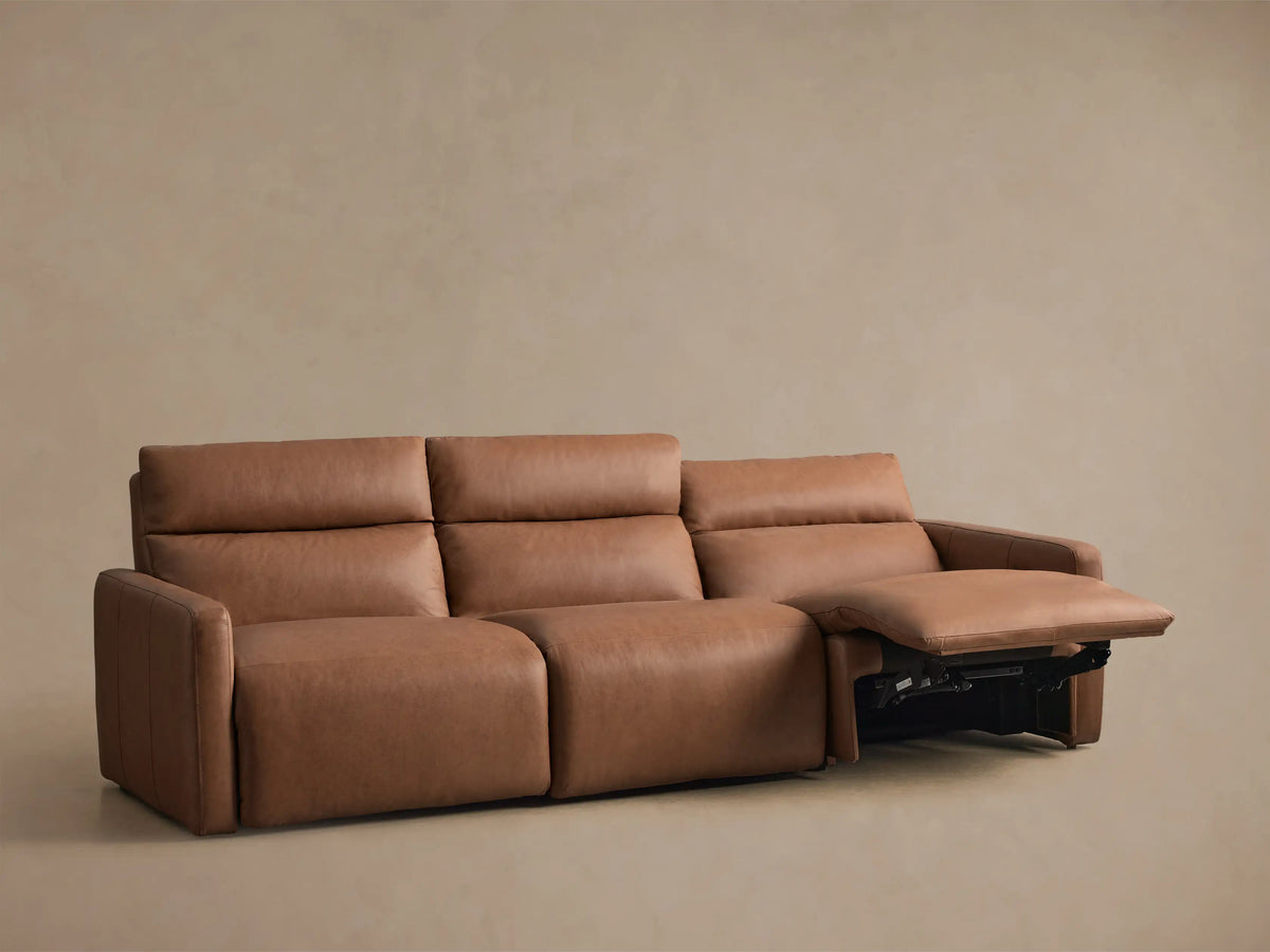 Angled back view of a Rowland Tailored Leather Three-Piece Motion Modular Sofa, showing three brown leather recliner sections.