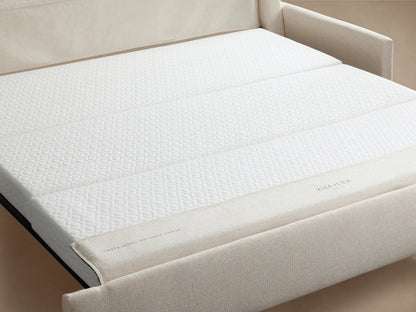Kipton Slim Arm Luxury King Sleeper Sofa in Wiley Parchment, a light cream-colored sofa with slim arms, on a wooden floor.