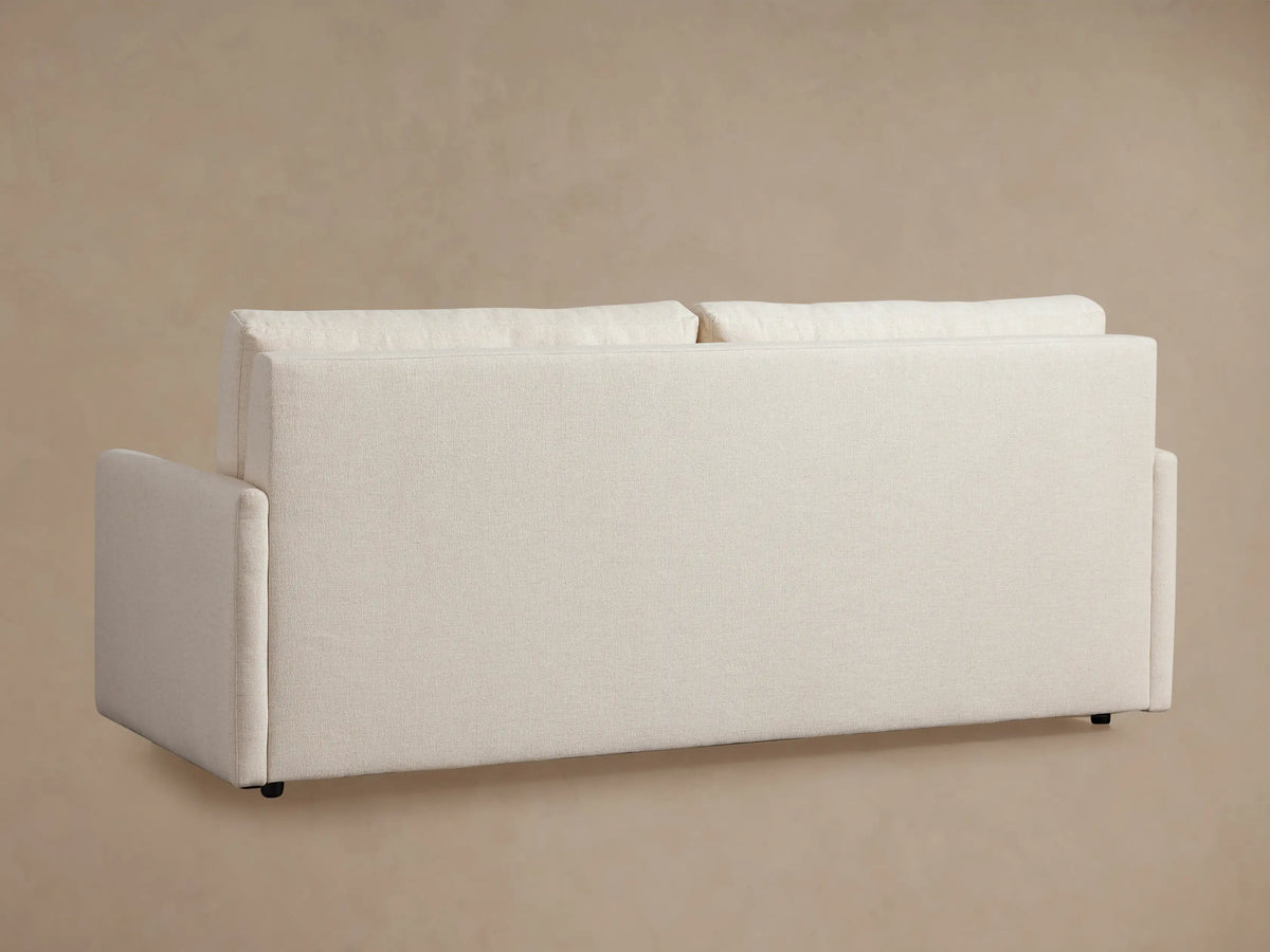 Kipton King Sleeper Sofa opened, showing a white textured mattress. Light beige fabric frame with slim arms visible.