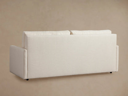 Kipton King Sleeper Sofa opened, showing a white textured mattress. Light beige fabric frame with slim arms visible.