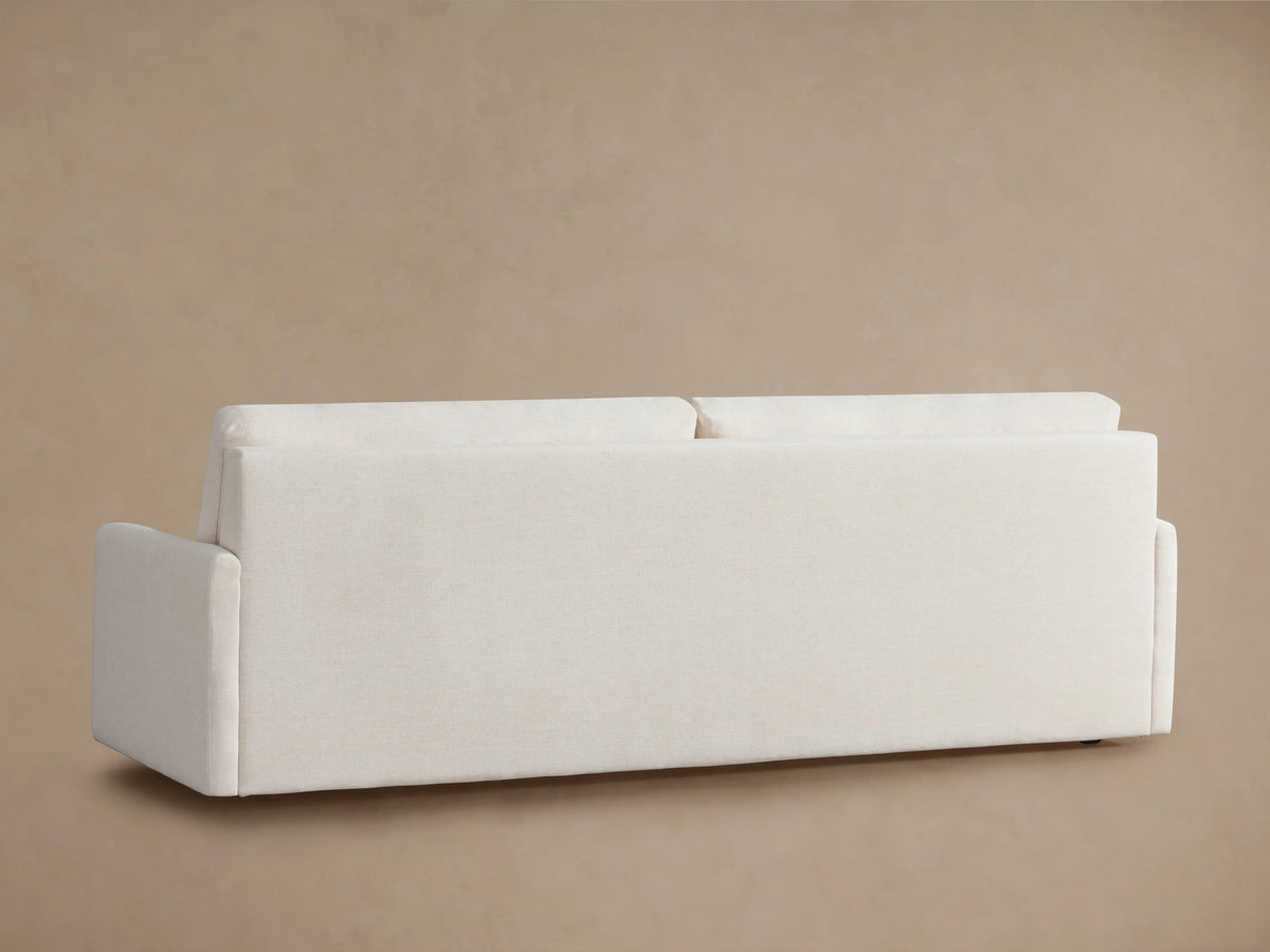 Kipton Luxury Sleeper Sofa in white fabric, showcasing its open mechanism with foam mattress partially extended, against a beige background.