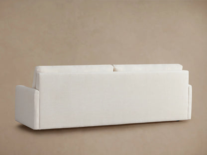 Kipton Luxury Sleeper Sofa in white fabric, showcasing its open mechanism with foam mattress partially extended, against a beige background.