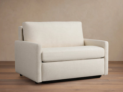 Kipton Slim Arm Luxury Twin Sleeper Chair in beige fabric, straight view. Features slim arms, plush seat, and back cushion on wooden floor.