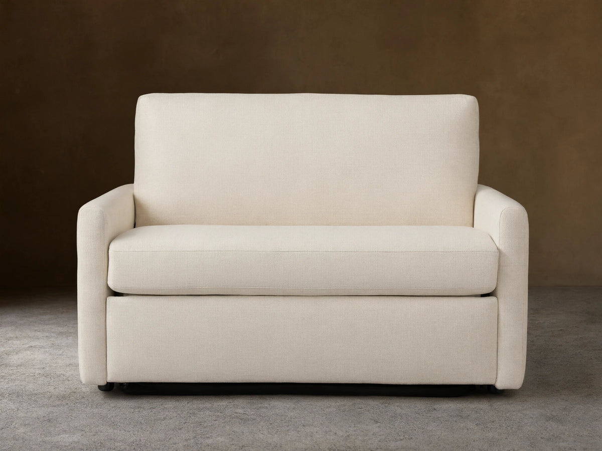 Kipton Slim Arm Luxury Twin Sleeper Chair in beige fabric, straight view. Features slim arms, plush seat, and back cushion on wooden floor.