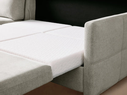 Light gray Reece Two-Piece Sleeper Chaise Sectional with three back cushions & left chaise, on wood floor against neutral wall.