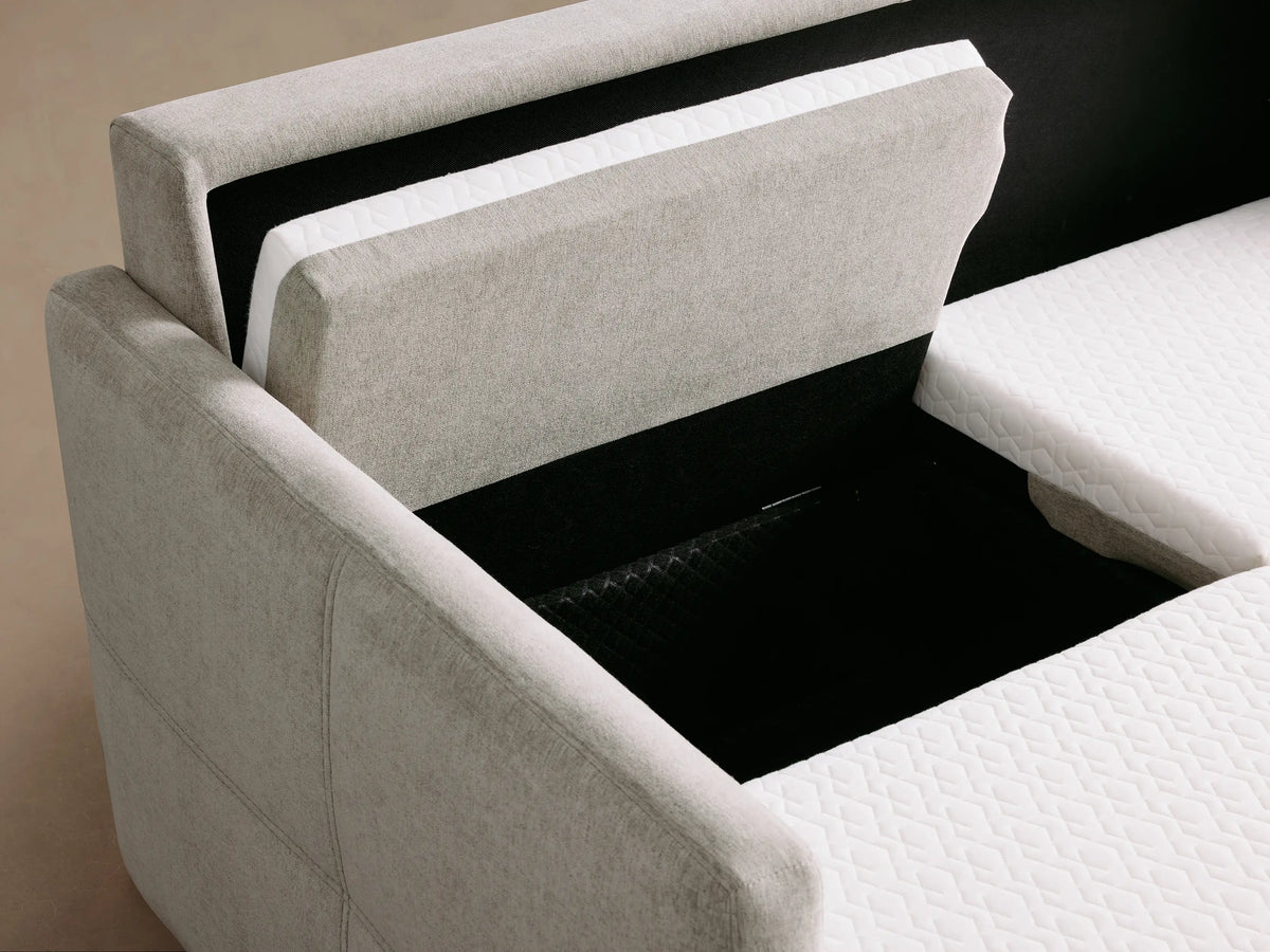 Close-up of a light gray Reece Sleeper Sofa unfolding, revealing its white quilted mattress and internal mechanism.