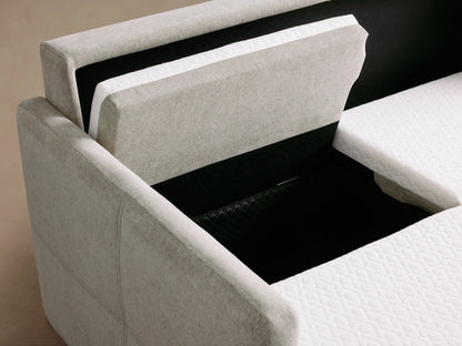 Close-up of a light gray Reece Sleeper Sofa unfolding, revealing its white quilted mattress and internal mechanism.
