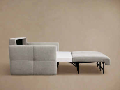 Back and side view of a light gray Reece Sleeper Sofa with textured fabric, two visible back cushions, and a subtly tufted left arm.