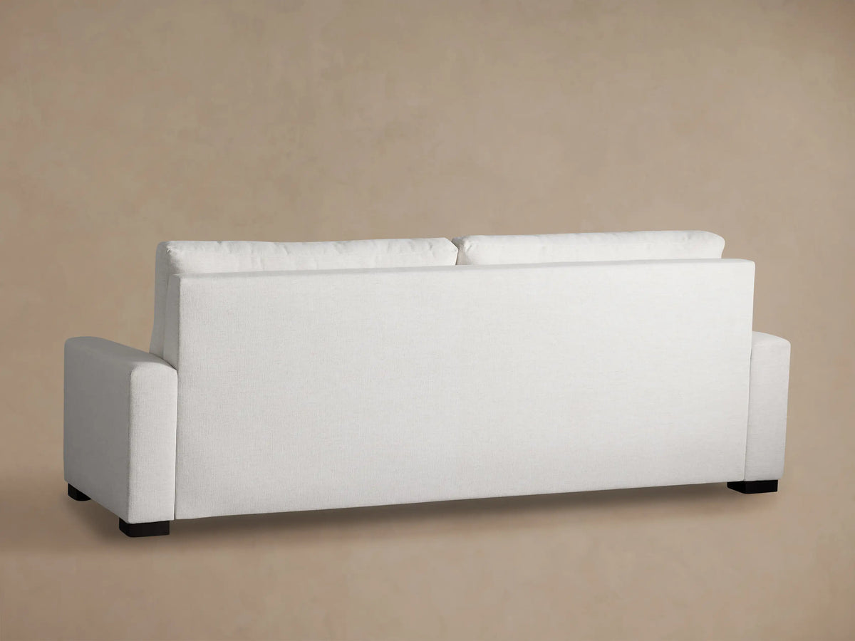 Close-up of a Remington Luxury Sleeper Sofa mattress, white quilted surface, with a fabric flap reading "BENCH CRAFTED UPHOLSTERY".