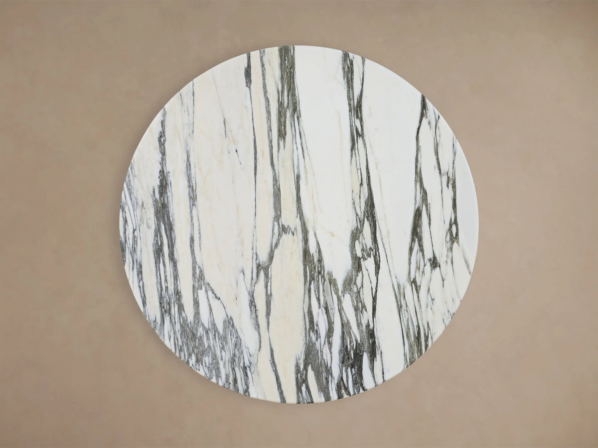 Front view of the Saint Germain Bar Table with a round white and gray marbled stone top and a dark, trumpet-shaped steel pedestal base.