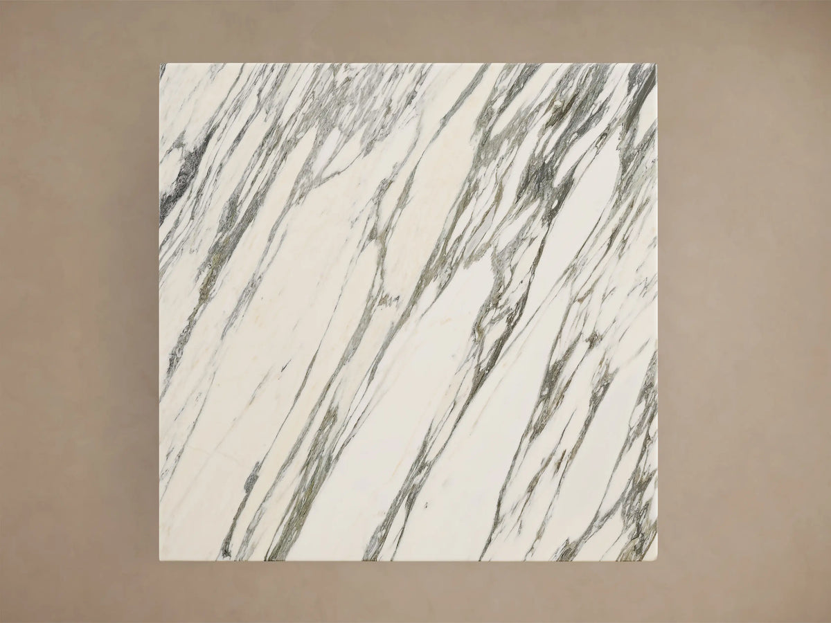 Close-up of the Saint Germain Square Bistro Table. White square marble top with gray and subtle green veining, above a gray metal base.